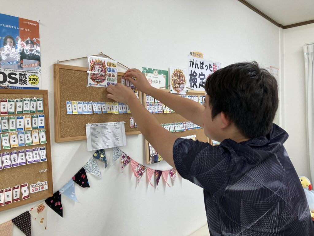 全種目の1級に合格して、合格ボードに名前を貼る大倉君。
